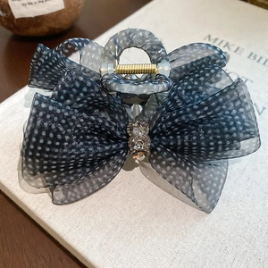 Detailed macro view of dark grey polka dot mesh bow hair claw with sparkling rhinestones