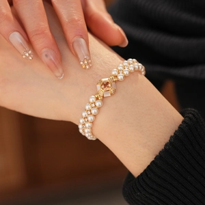 Gros plan sur un élégant bracelet de perles à double rangée avec charme en pierre orange