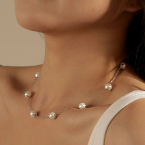 Detail shot of the S925 sterling silver necklace with spaced white pearls on skin