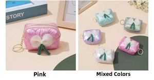 Close-up of quilted bow mini pouches with gold keyrings and lace ribbon details