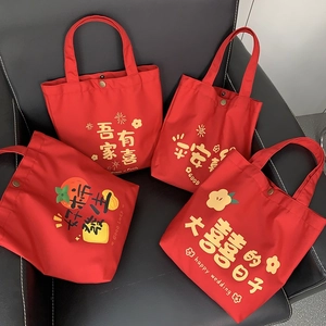 Detail of red wedding canvas tote bags with gold snap buttons and festive prints