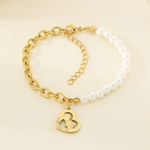 Detail of gold titanium steel bracelet with white pearls and heart pendant