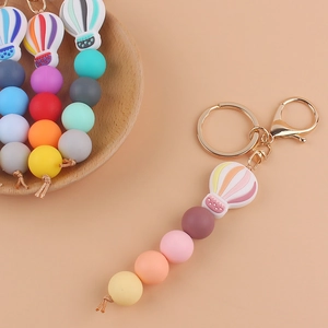 Detailed view of colorful silicone bead keychain with hot air balloon charm and gold clasp