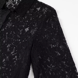 Detailed close-up of intricate black lace texture and patterns on the long sleeve shirt