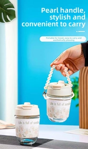 Detail of a glass tumbler with a daisy print sleeve and a stylish pearl beaded handle