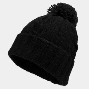 Close-up of black cable knit beanie with fluffy pom-pom and thick ribbed texture