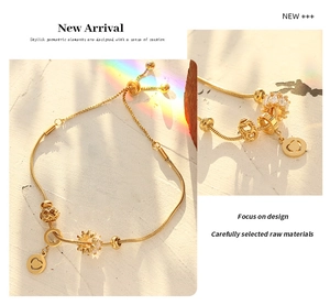 Detail of adjustable 18K gold-plated snake chain bracelet with heart and crown charms