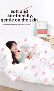 Detail of disposable bedding set with pink cartoon dinosaur pattern on soft white fabric