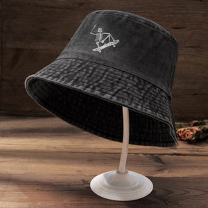 Close-up of vintage washed grey bucket hat featuring a skull skateboarder embroidery