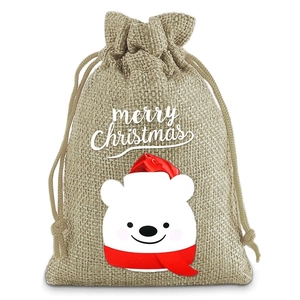 Detail of Christmas burlap gift bag featuring a cute polar bear and merry christmas text