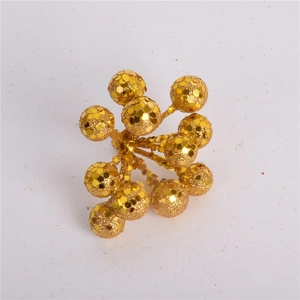 Close-up of sparkling gold glitter berry stems for Christmas tree and wreath DIY decor