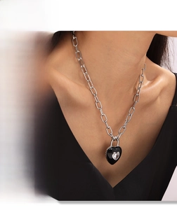 Dettaglio catena argento con ciondolo a cuore nero e zircone su modella donna
