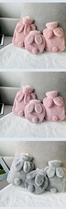 Detailed view of pink and grey plush rabbit-themed hot water bottles with soft faux fur texture