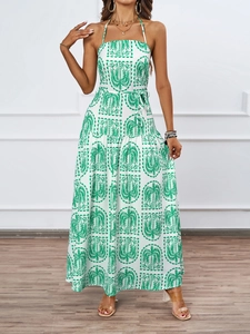Detail of tropical palm leaf print on women's green and white halter neck maxi dress