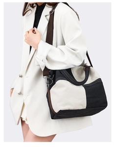 Detail view of contrast canvas tote bag with wide brown straps worn with white blazer