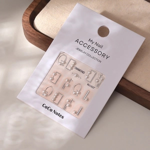 Detailed close-up of 5D pearl nail art stickers with silver accents on display card