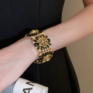 Detailed macro view of vintage gold camellia bracelet with sparkling diamonds and black resin