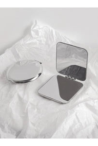 Close-up of portable silver metal makeup mirrors in round closed and square open views