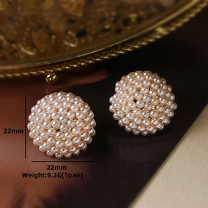 Macro shot of 22mm cream pearl stud earrings with gold plating and paved details