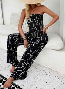 Black strapless jumpsuit with white abstract print and wide-leg cut on a female model