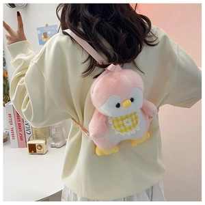 Close-up of pink and white plush penguin backpack with a yellow plaid bib on a model