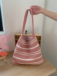 Detail of pink and white striped hand-knitted tote bag with cotton yarn texture
