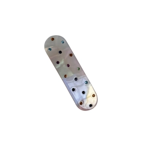 Translucent acetate hair clip with colorful rhinestones and textured bumps on white background
