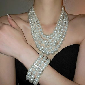 Detail of elegant multi-layer pearl necklace and bracelet set on a female model