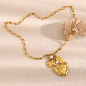 Macro shot of 18K gold plated heart pendant with I Love You engraving and white pearl detail