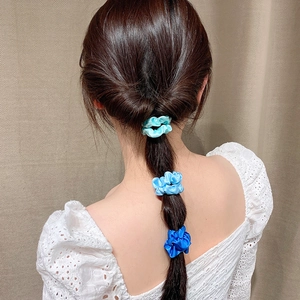 Three gradient blue satin scrunchies set on hair, featuring silky texture and elastic band