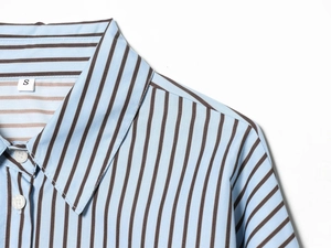 Close-up of a blue striped poplin shirt collar and shoulder with a size S label
