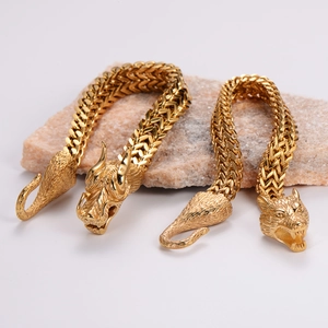 Close-up of gold double-layer Viking wolf and dragon head pendants on braided steel chains