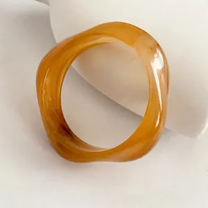 Minimalist amber resin geometric square bangle with a modern irregular twisted design
