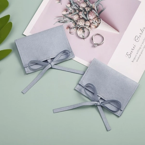 Macro detail of light blue velvet jewelry pouches with ribbon and ring storage scene