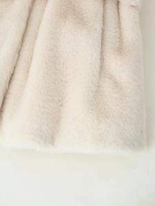 Macro shot showing thick soft faux fur texture on the off-white winter coat material