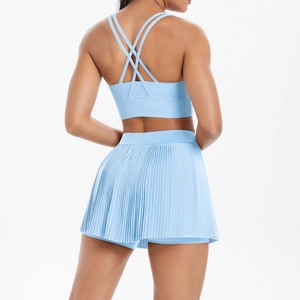 Detail of light blue sports bra with criss-cross back straps and pleated tennis skirt