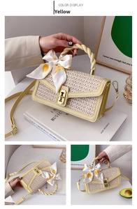 Detail of straw crossbody bag with yellow faux leather, twist handle and silk scarf