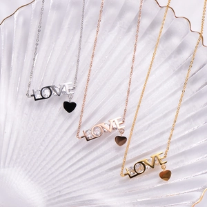 Macro shot of LOVE letter pendants with zircon inlay in gold, silver, and rose gold finishes
