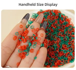Close-up of mini PVC chili rings and green onion accessories held by hand for size comparison