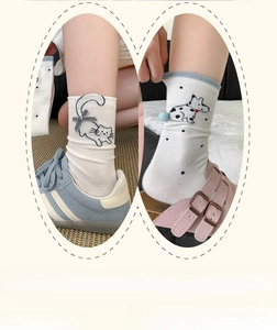 Close-up of cute beige mid-calf socks with cat and dog jacquard and bow detail