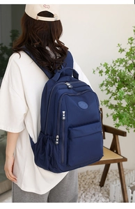 Detail of navy blue nylon backpack with multiple compartments and sturdy zippers