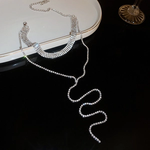 Detail of silver rhinestone choker necklace with layered fringes on reflective black surface