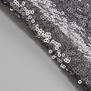 Détail macro de paillettes argentées sur tulle noir pour robe d'été élégante