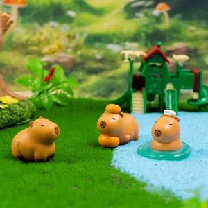 Three cute resin capybara figurines in a miniature park scene for desktop decor