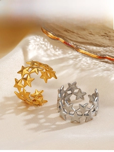 Detailed view of silver and gold star rings on elegant satin with glass accents