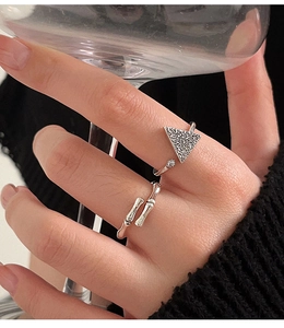 Detalle de anillos abiertos S925 de plata de ley con textura de bambú y triángulo en mano