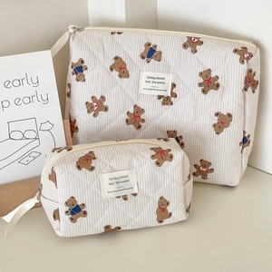 Close-up of quilted teddy bear makeup bag set with brown stripes and zipper detail