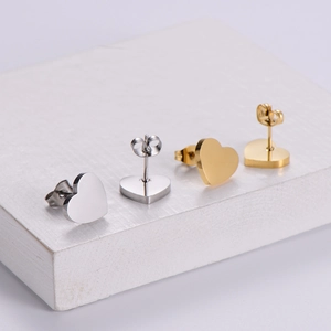 Polished metal heart stud earrings in gold and silver finish on a display stand