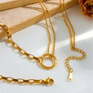 Elegant gold titanium steel double chain necklace set with central ring on stone surface