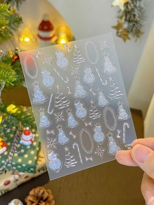 Detailed view of silver glitter Christmas nail stickers with snowman and tree patterns